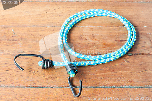 Image of Elastic rope with metal hooks on wooden table