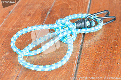 Image of Light blue elastic rope on wood background