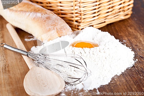 Image of bread, flour, eggs and kitchen utensil 