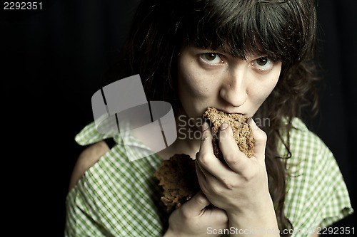 Image of beggar woman eating bread 