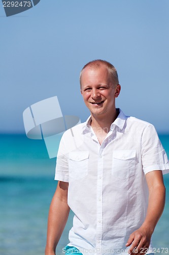 Image of young man walking on the beach in holiday