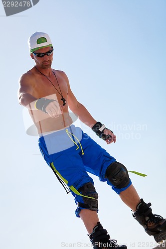 Image of young man with inline skates in summer outdoor 