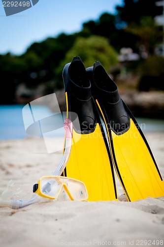 Image of yellow fins and snorkelling mask on beach in summer