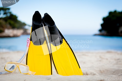 Image of yellow fins and snorkelling mask on beach in summer