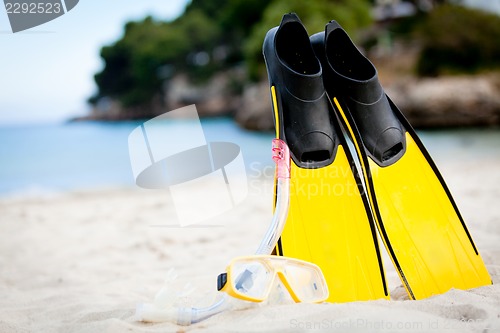 Image of yellow fins and snorkelling mask on beach in summer