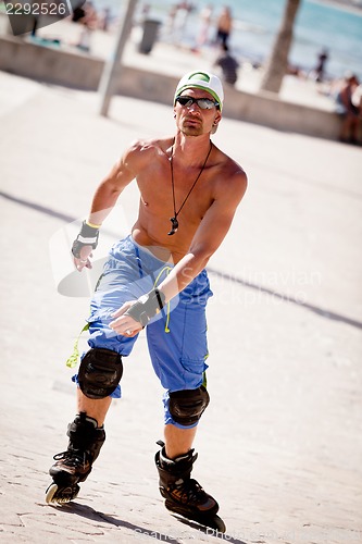 Image of young man with inline skates in summer outdoor 