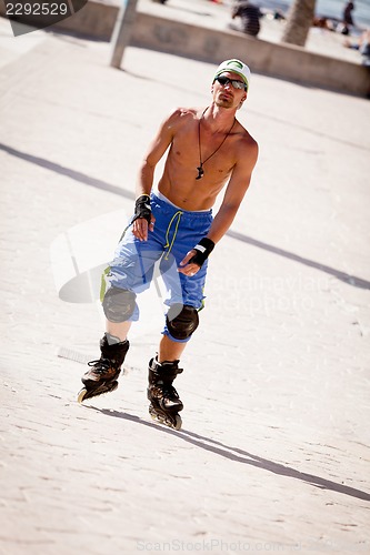 Image of young man with inline skates in summer outdoor 