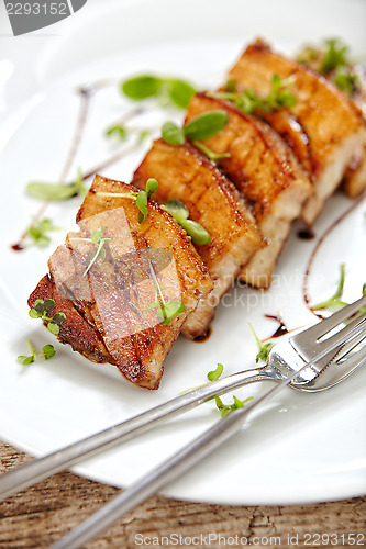 Image of grilled pork on white plate, restaurant portion