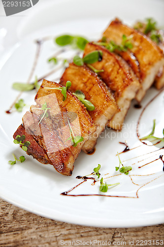 Image of grilled pork on white plate, restaurant portion
