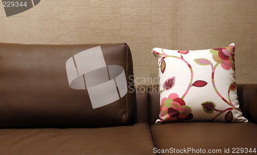 Image of Floral pillow on a brown leather couch - home interiors