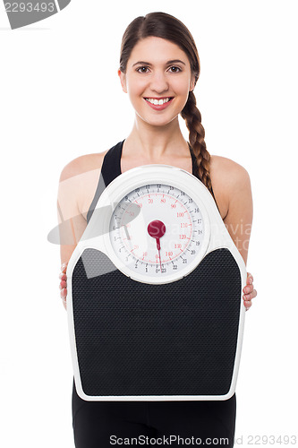 Image of Young girl holding weighing machine
