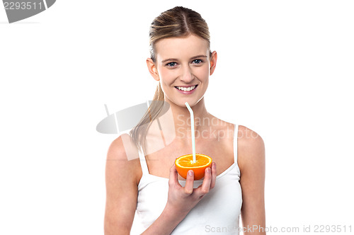 Image of Girl sipping orange juice through straw