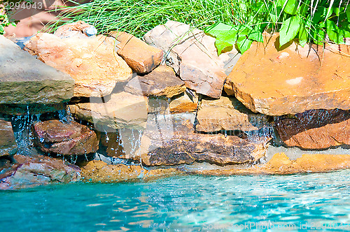 Image of waterfall falling in a blue swimming pool