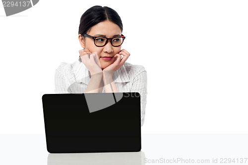 Image of Businesswoman at her work desk, looking away