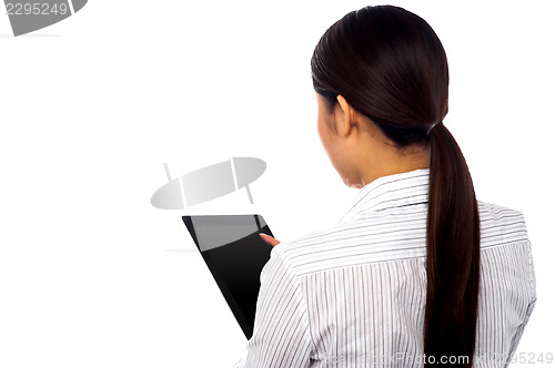 Image of Back pose of a woman operating touch pad device