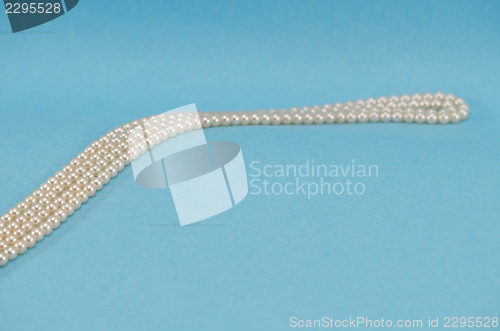 Image of pearl necklace collar curve close blue background 