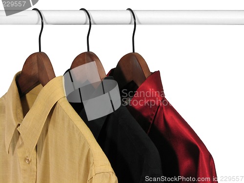 Image of Colorful shirts on hangers, on white background