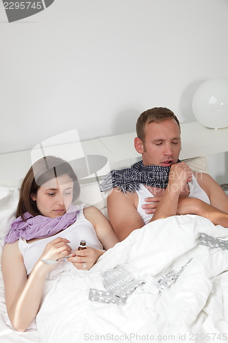 Image of Husband and wife in bed with a winter cold