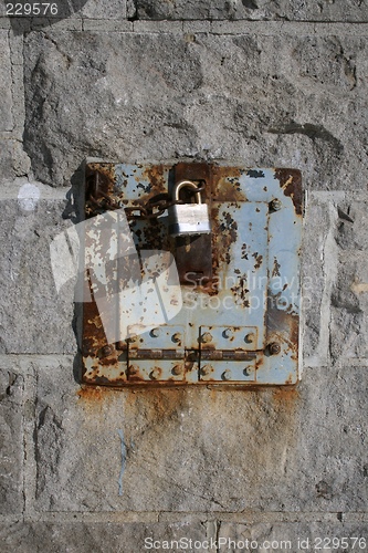 Image of Iron lock and rusty chain on a stone wall
