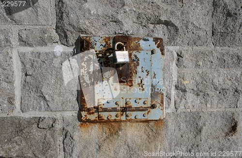 Image of Iron lock and rusty chain on a stone wall