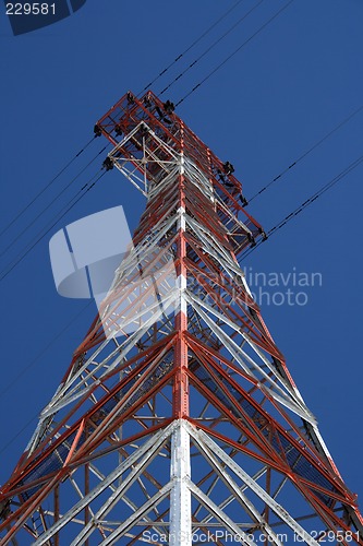 Image of Red and white electricity pylon against the blue sky