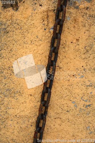 Image of Rusty chain on a stone wall