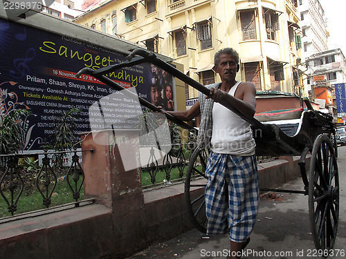 Image of Men wait for passengers on their rickshaw