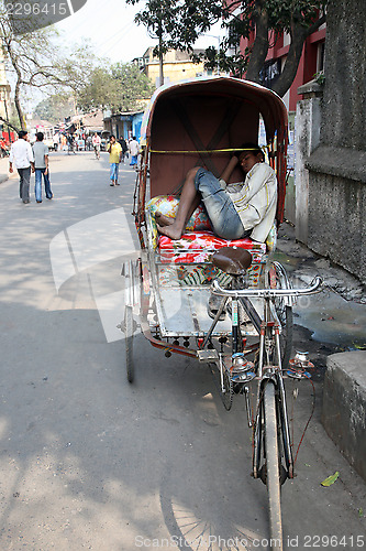 Image of Men wait for passengers on their rickshaw