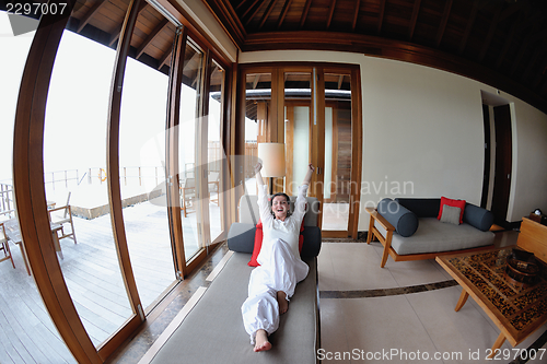 Image of happy young woman relax at home on sofa