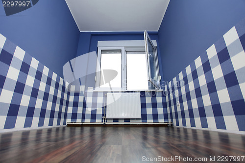 Image of empty room with a blue wall and blue-white wallpaper 
