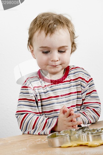 Image of child child looking at backing utensil