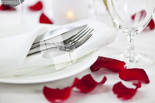 Image of Romantic dinner setting with rose petals