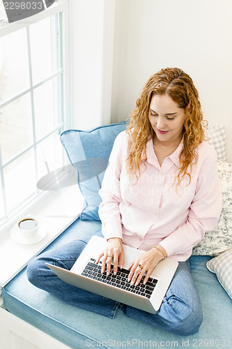 Image of Woman using laptop computer at home