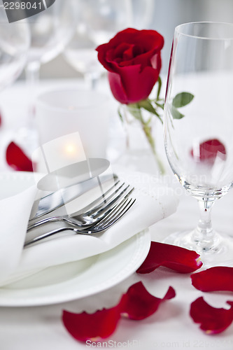 Image of Romantic dinner setting with rose petals