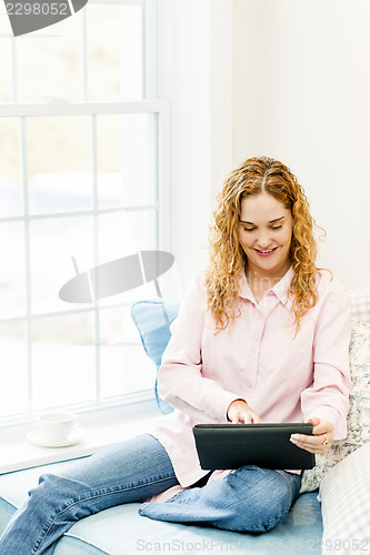 Image of Woman with tablet computer at home