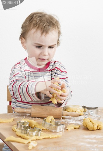 Image of young child with dough in grey background