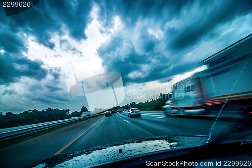 Image of dramtatic sky and clouds with some rain while driving on a highw