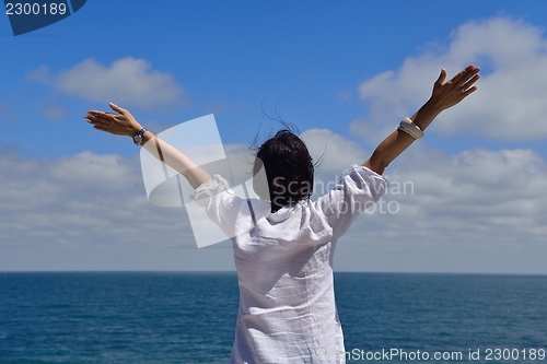 Image of young woman with spreading arms to sky