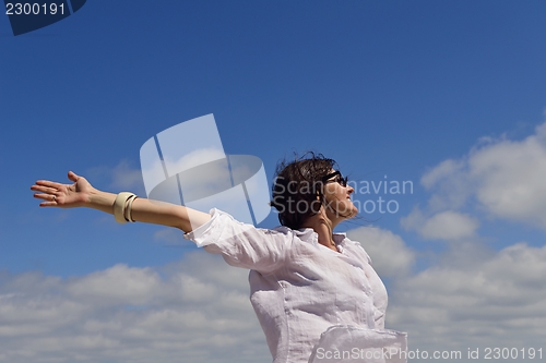 Image of young woman with spreading arms to sky