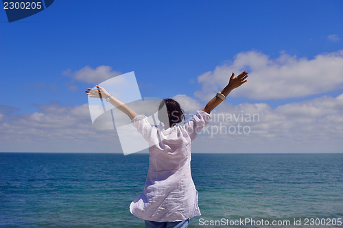 Image of young woman with spreading arms to sky