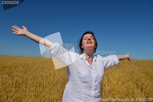 Image of young woman in wheat field at summer
