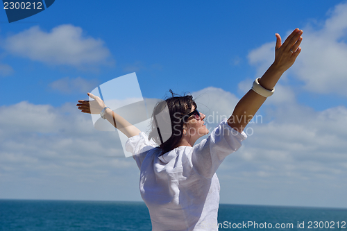 Image of young woman with spreading arms to sky