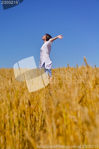 Image of young woman in wheat field at summer