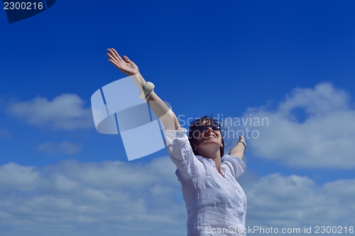 Image of young woman with spreading arms to sky