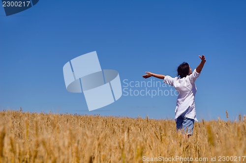 Image of young woman in wheat field at summer