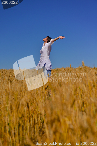 Image of young woman in wheat field at summer