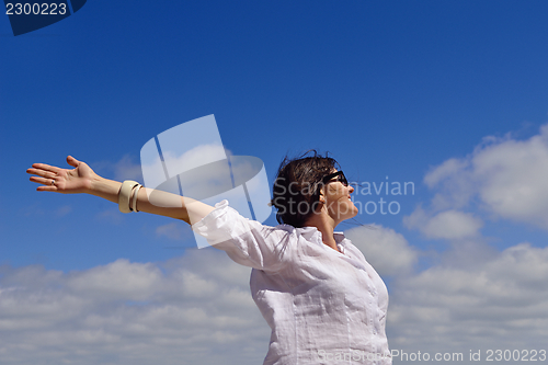 Image of young woman with spreading arms to sky