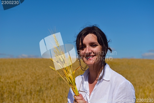Image of young woman in wheat field at summer