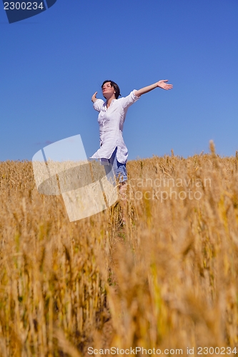 Image of young woman in wheat field at summer