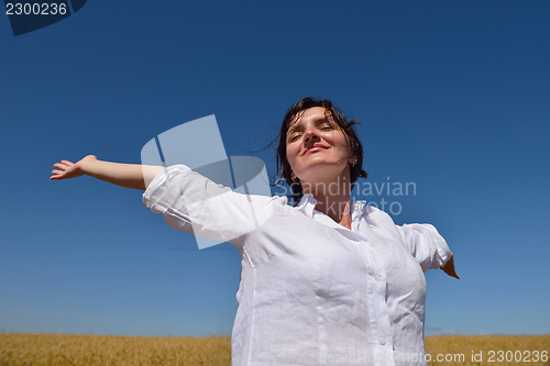 Image of young woman in wheat field at summer